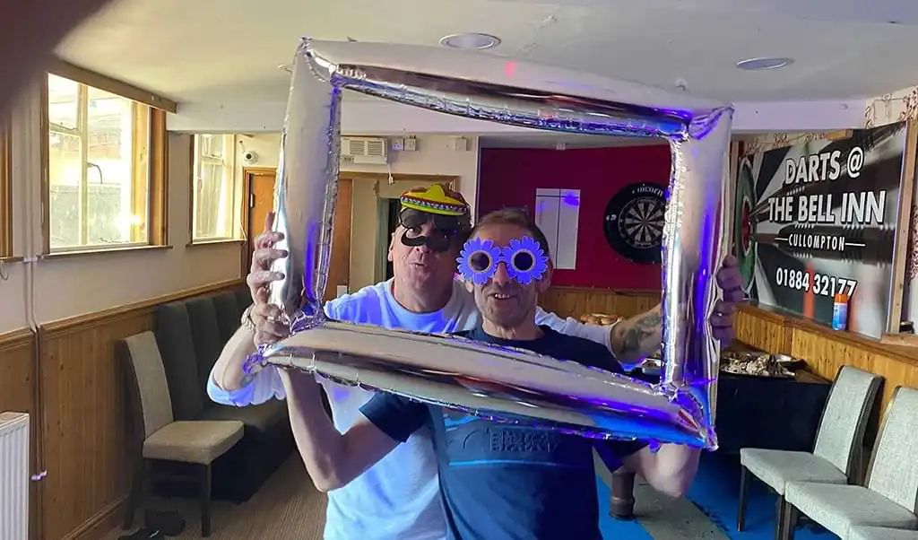 Ryan&#039;s Dad, Nigel and Dave wearing funny faces behind a blow-up picture frame