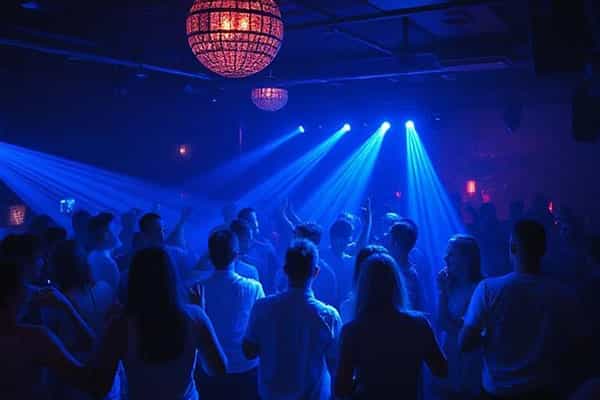 Crowd of people dancing at a disco with blue lighting